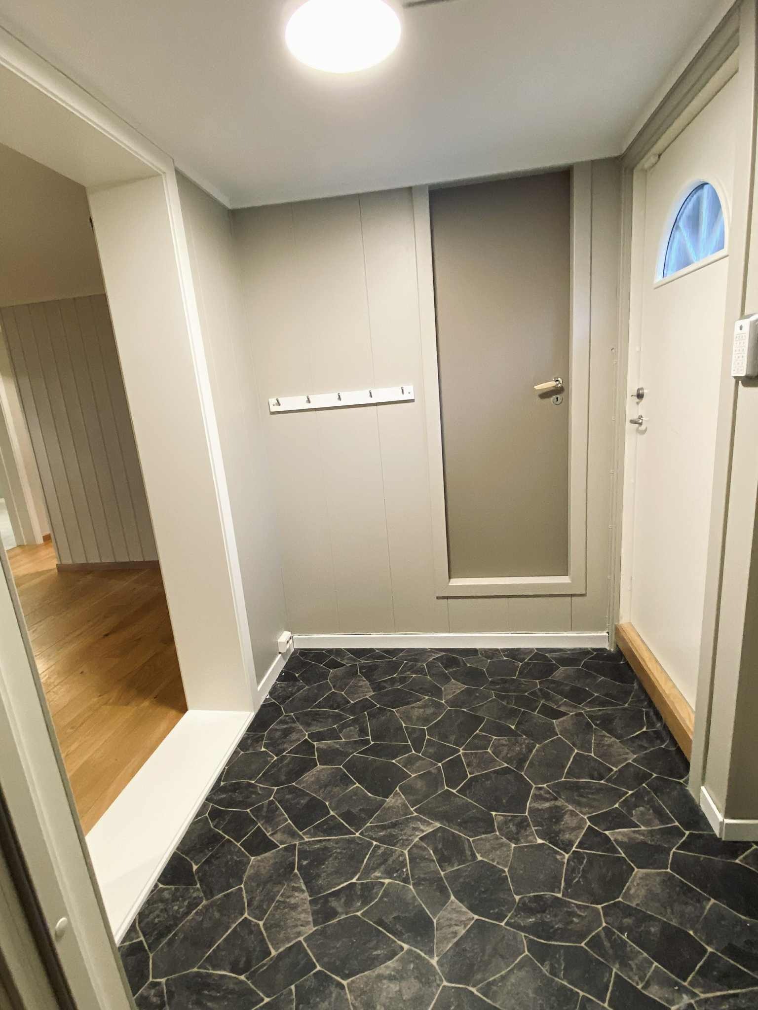 Gang med dør inn til stor bod. 